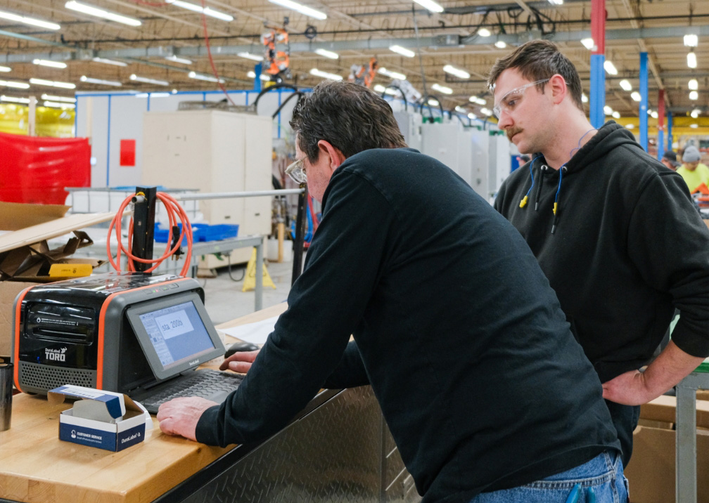 two men setting up label printer