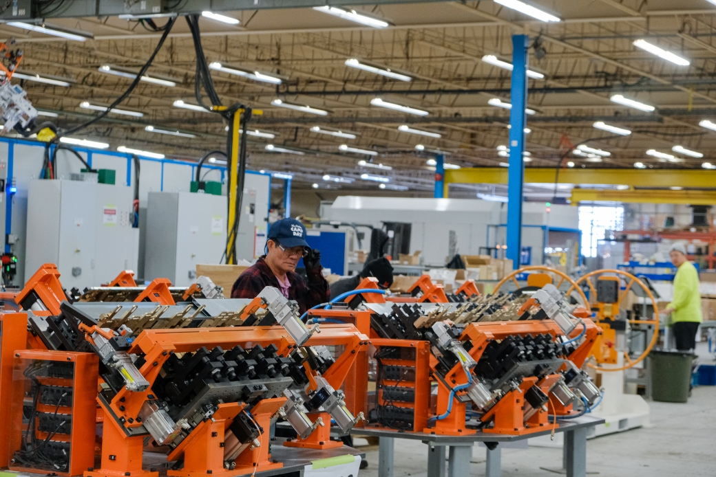 man working on assembling components of an assembly system