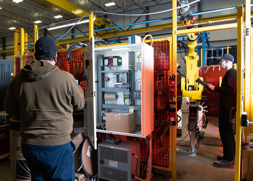 Two workers overseeing inner mechanical mechanisms