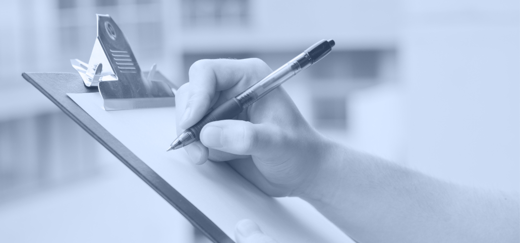 A hand writing on a clipboard